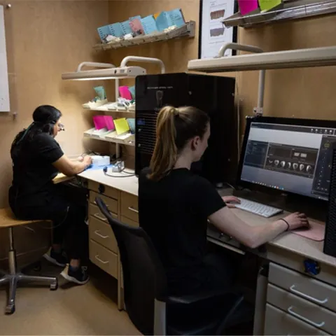 Two of our team working at the benches of the in-house lab.