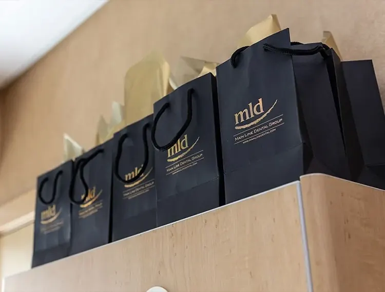 Main Line Dental Group gift bags on a cabinet.