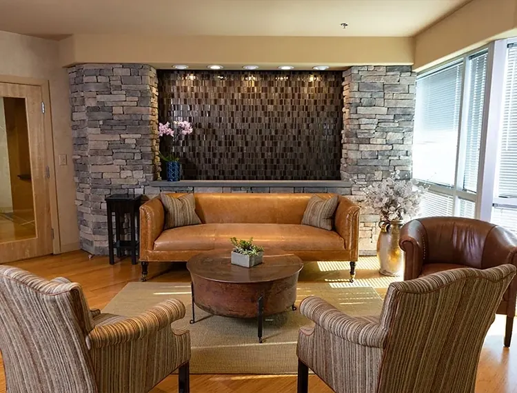 The lobby at Main Line Dental Group, with leather seating beneath a mosaic stone wall.