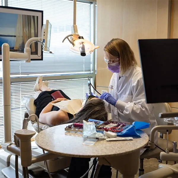 A hygienist cleaning a patient's teeth in one of our treatment rooms.